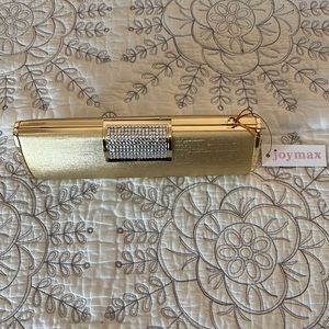 NWT. Gold clutch with stones in clasp. Includes dust bag. 8”x3”.